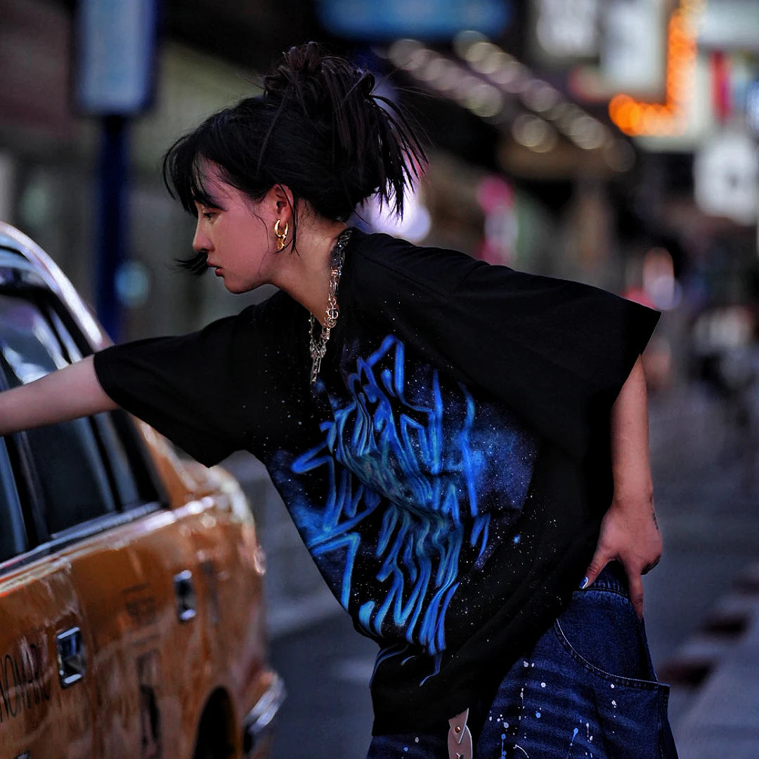 Sanhoostudio short sleeve T-shirt featuring galaxy-inspired graphic artwork, breathable fabric, and a relaxed oversized fit. Perfect for summer streetwear styling with comfort, creativity, and everyday wearability.