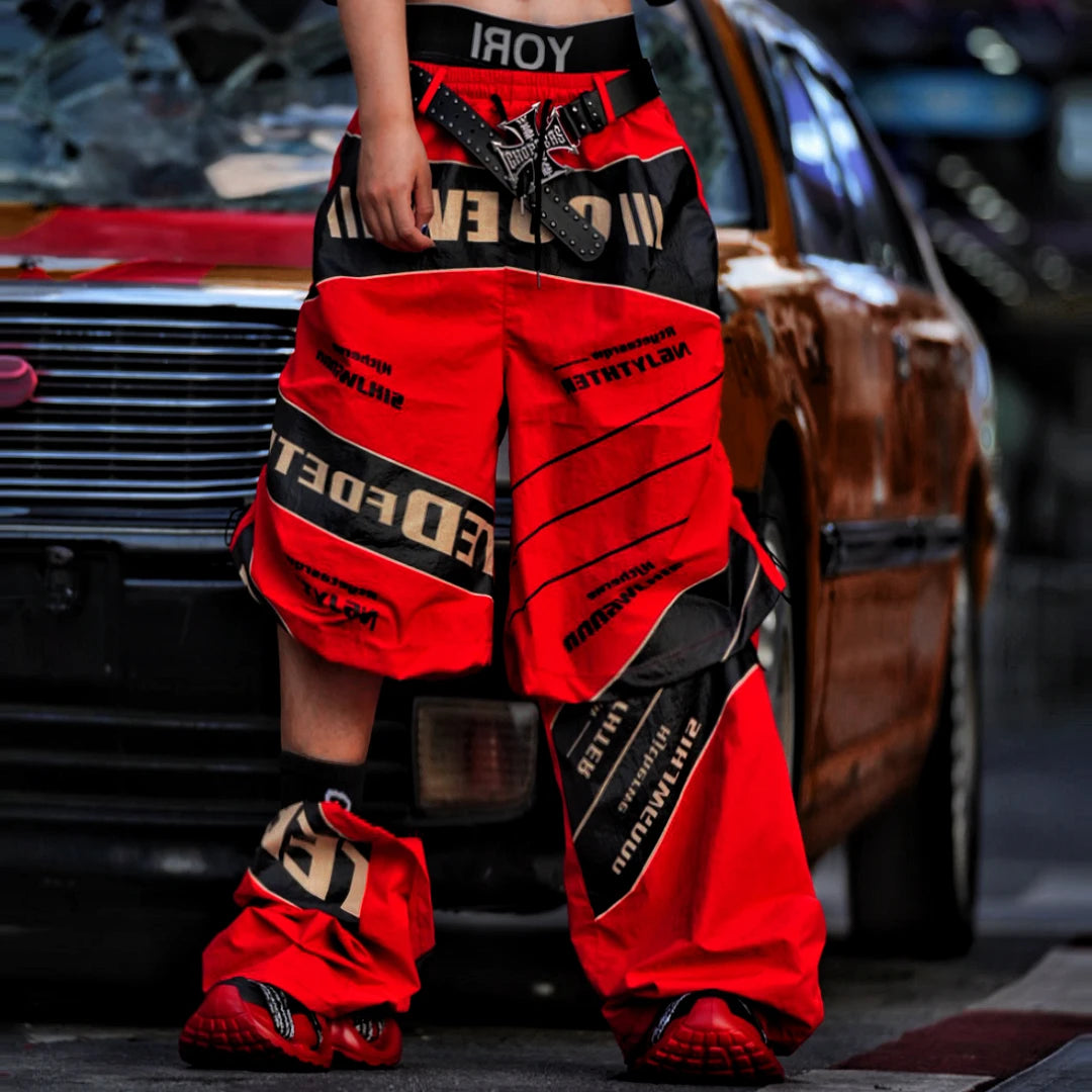 Sanhoostudio wide leg pants featuring detachable styling elements, racing-inspired panel construction, and a relaxed fit. Designed for modern streetwear outfits with comfort, versatility, and bold visual appeal.