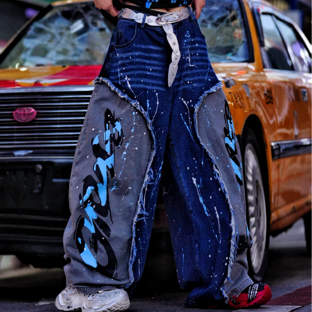 Sanhoostudio denim pants featuring distressed wash treatment, patchwork detailing, and a wide leg scythe-cut silhouette. Designed for contemporary streetwear styling with comfort and standout structure.