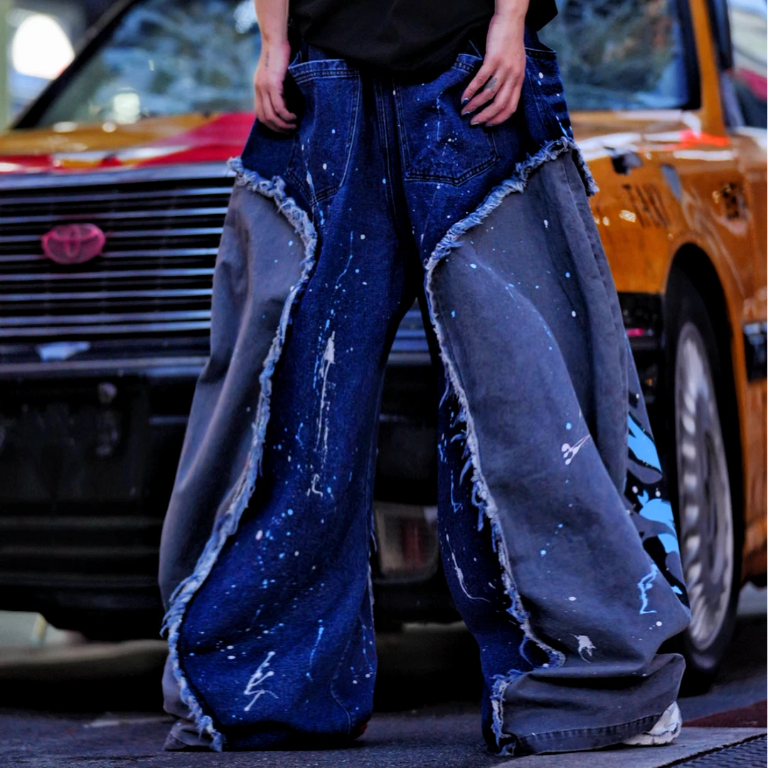 Sanhoostudio denim pants featuring distressed wash treatment, patchwork detailing, and a wide leg scythe-cut silhouette. Designed for contemporary streetwear styling with comfort and standout structure.