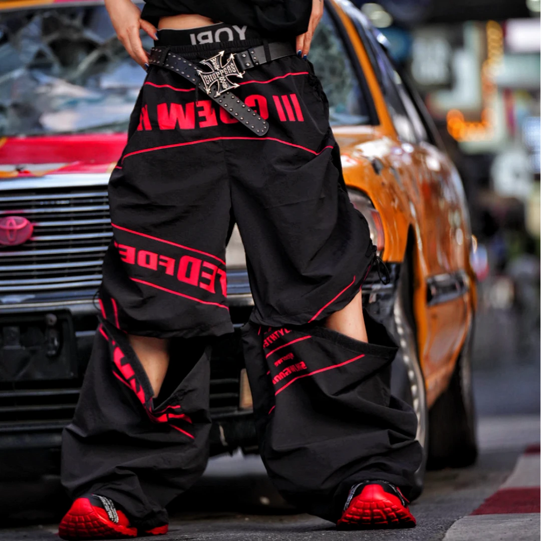 Sanhoostudio track pants featuring detachable design details, racing-inspired panel construction, and lightweight quick-dry fabric. Built for active streetwear styling with comfort, flexibility, and everyday versatility.