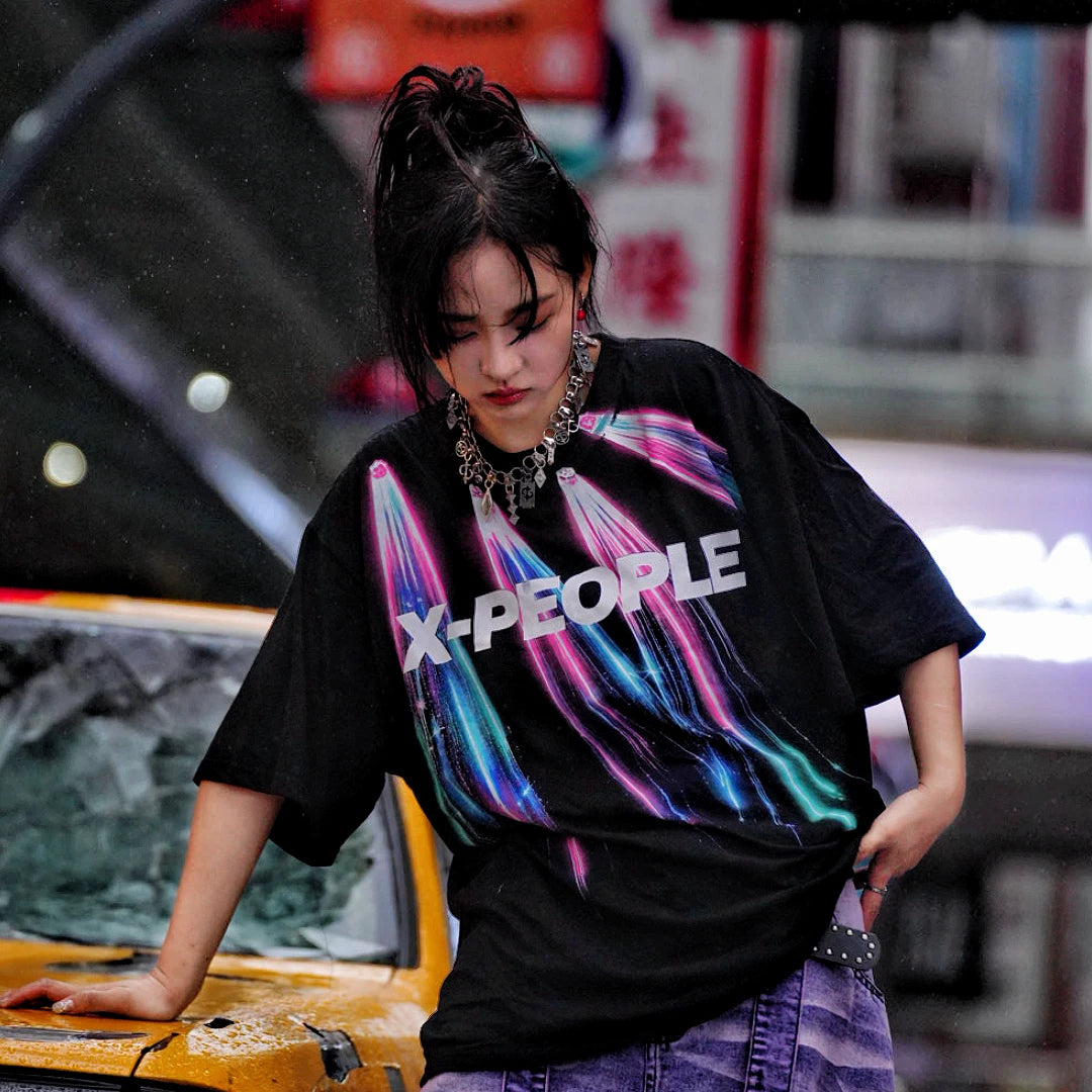 Sanhoostudio short sleeve T-shirt featuring colorful spray-print artwork, breathable fabric construction, and an oversized silhouette. Designed for summer streetwear styling with lightweight comfort and bold graphic appeal.