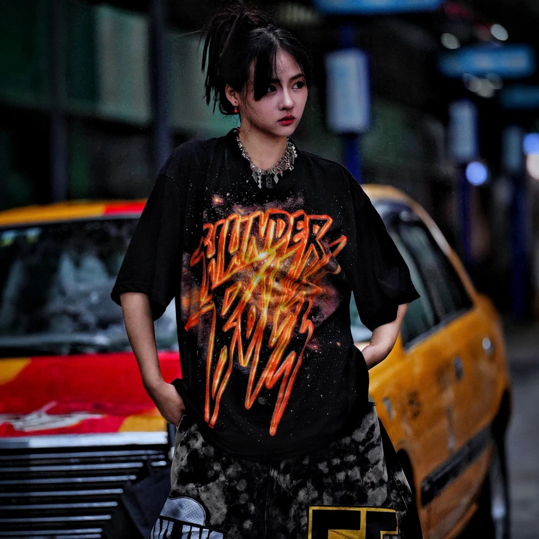Sanhoostudio short sleeve T-shirt featuring gold-inspired spray-print graphics, breathable fabric construction, and a relaxed oversized fit. Built for standout summer streetwear outfits with comfort and unique visual expression.