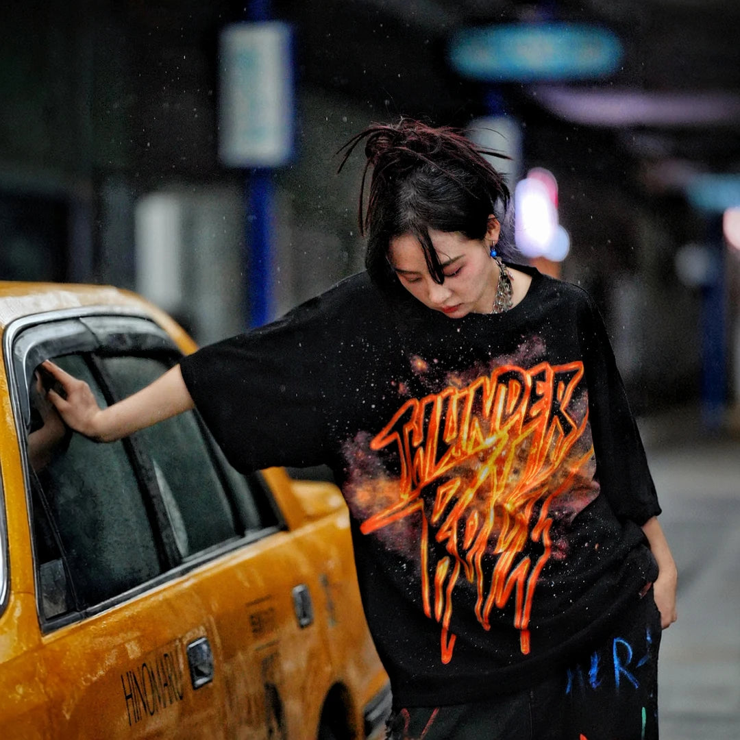 Sanhoostudio short sleeve T-shirt featuring gold-inspired spray-print graphics, breathable fabric construction, and a relaxed oversized fit. Built for standout summer streetwear outfits with comfort and unique visual expression.