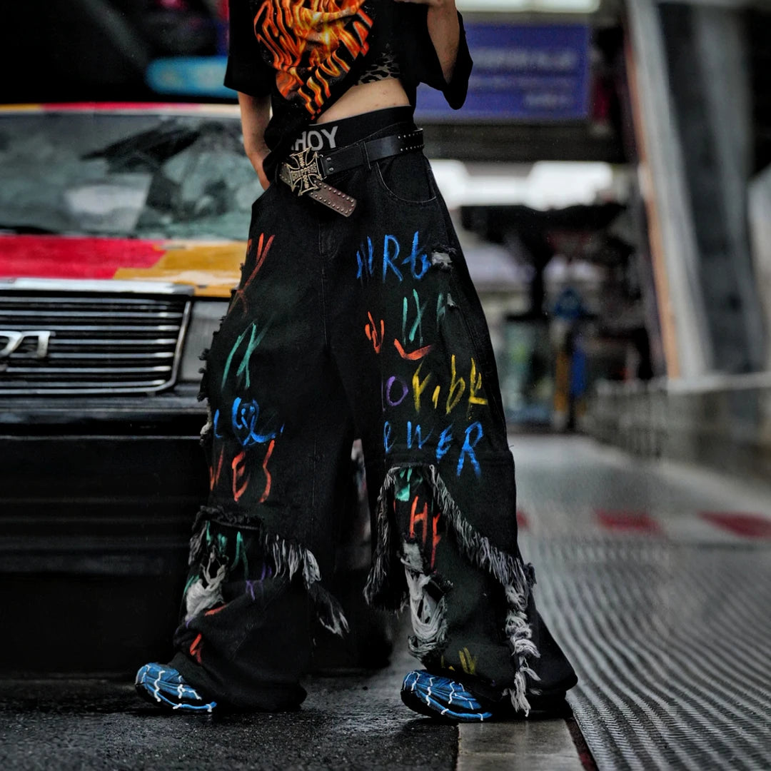 Sanhoostudio convertible denim pants featuring detachable long-to-short functionality, distressed wash treatment, and a wide leg scythe-cut silhouette. Designed for versatile streetwear styling with comfort and standout visual appeal.
