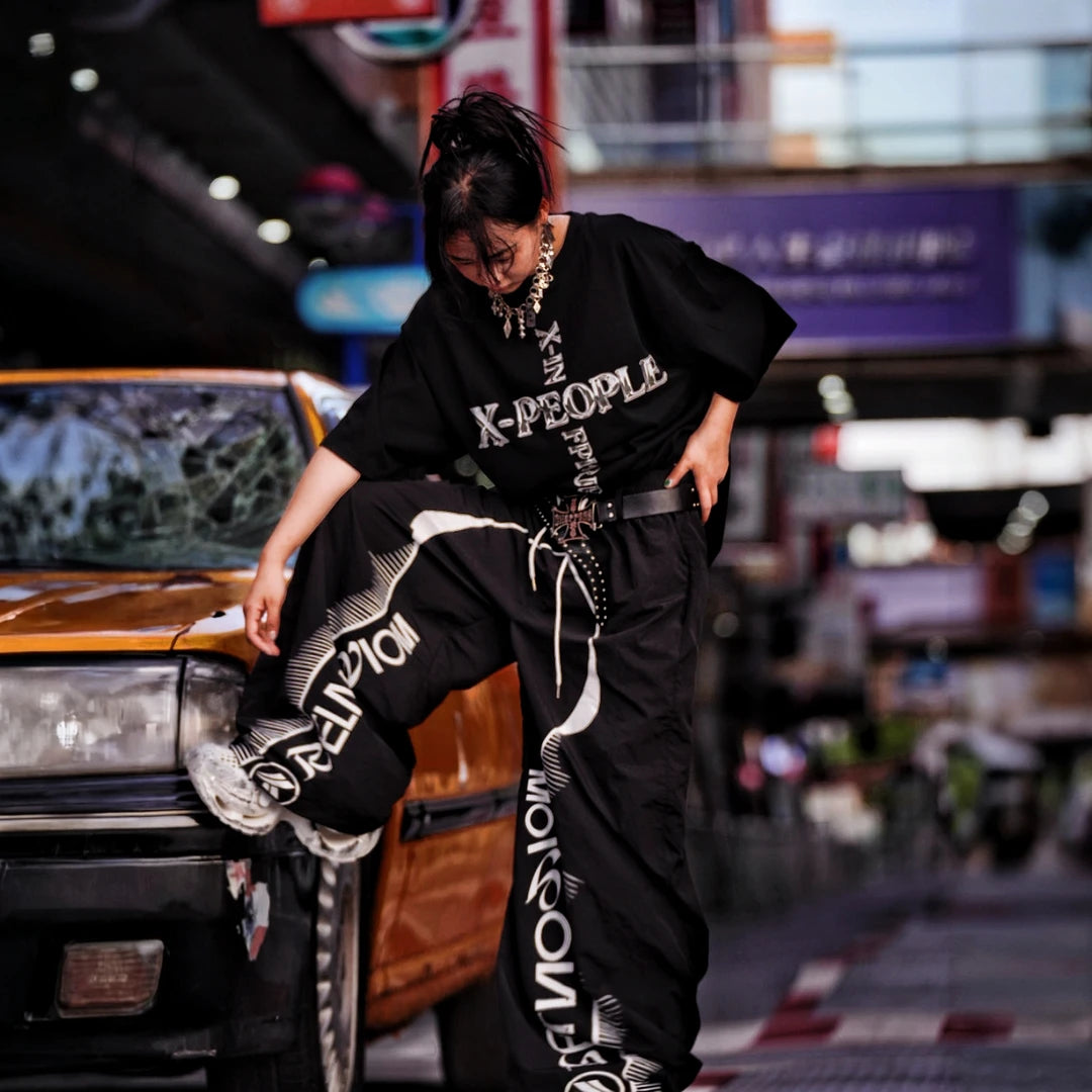 Sanhoostudio wide leg pants featuring quick-dry fabric construction, lightweight comfort, and a scythe-cut silhouette with patchwork details. Designed for breathable summer streetwear styling with relaxed movement and everyday versatility.