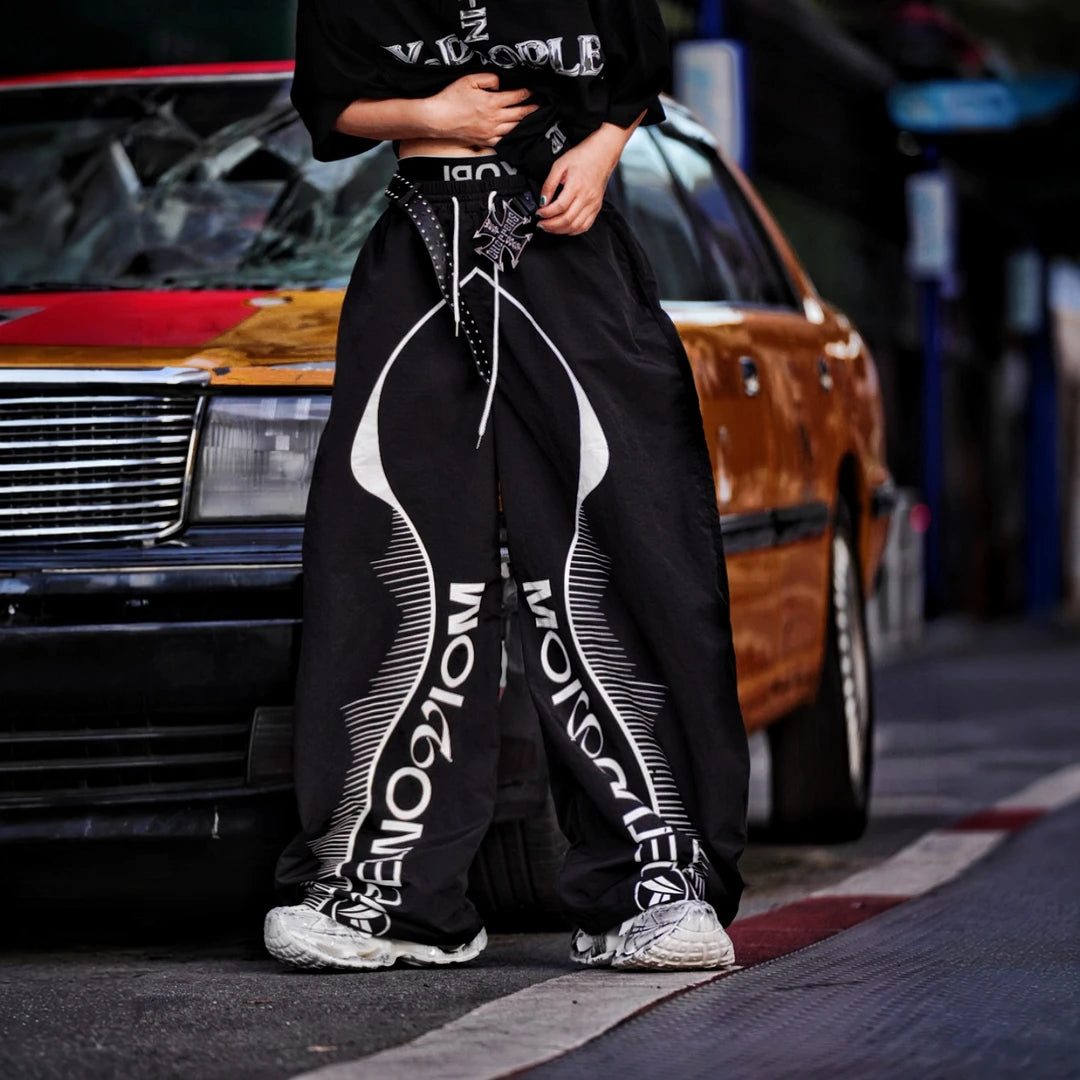 Sanhoostudio wide leg pants featuring quick-dry fabric construction, lightweight comfort, and a scythe-cut silhouette with patchwork details. Designed for breathable summer streetwear styling with relaxed movement and everyday versatility.