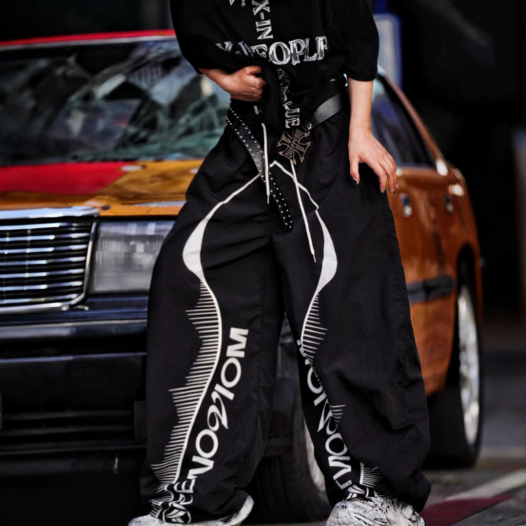 Sanhoostudio wide leg pants featuring quick-dry fabric construction, lightweight comfort, and a scythe-cut silhouette with patchwork details. Designed for breathable summer streetwear styling with relaxed movement and everyday versatility.