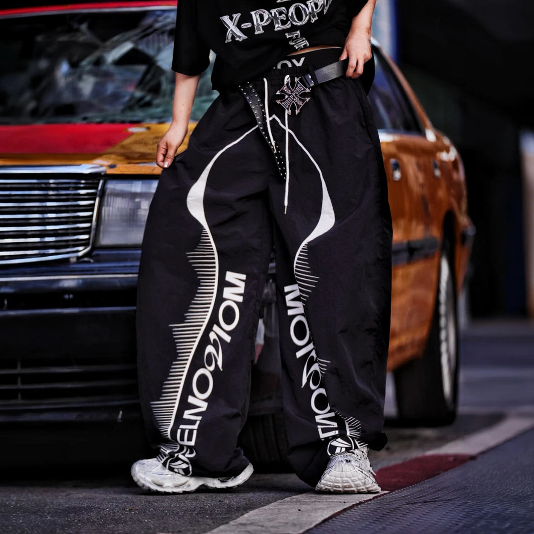 Sanhoostudio wide leg pants featuring quick-dry fabric construction, lightweight comfort, and a scythe-cut silhouette with patchwork details. Designed for breathable summer streetwear styling with relaxed movement and everyday versatility.