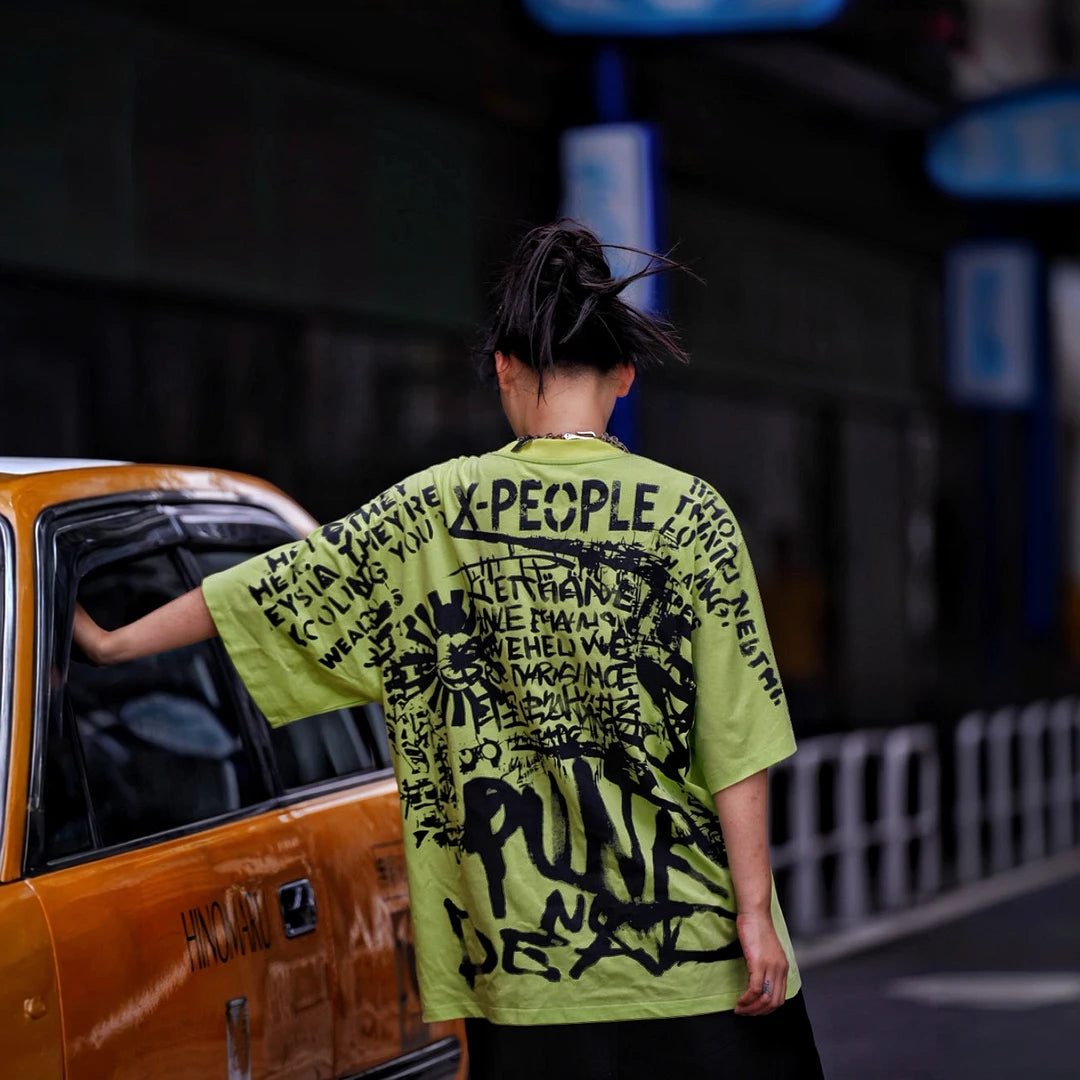 Sanhoostudio short sleeve T-shirt featuring spray-print artwork, breathable fabric construction, and an oversized fit silhouette. Designed for modern streetwear styling with comfort and standout summer appeal.