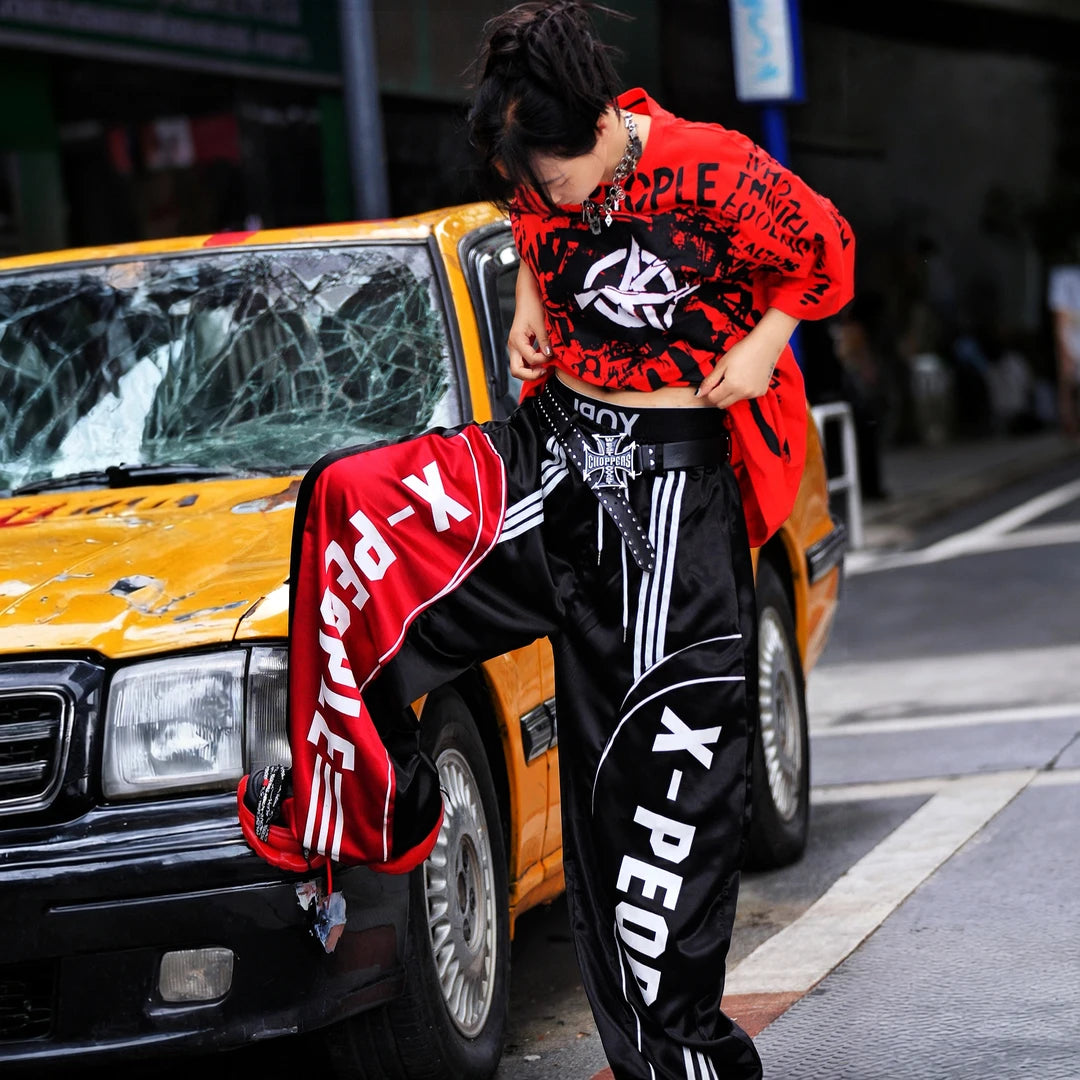 Sanhoostudio wide leg pants featuring lightweight glossy fabric construction and a scythe-cut silhouette with a relaxed fit. Designed for breathable summer styling with comfort, movement, and contemporary streetwear appeal.