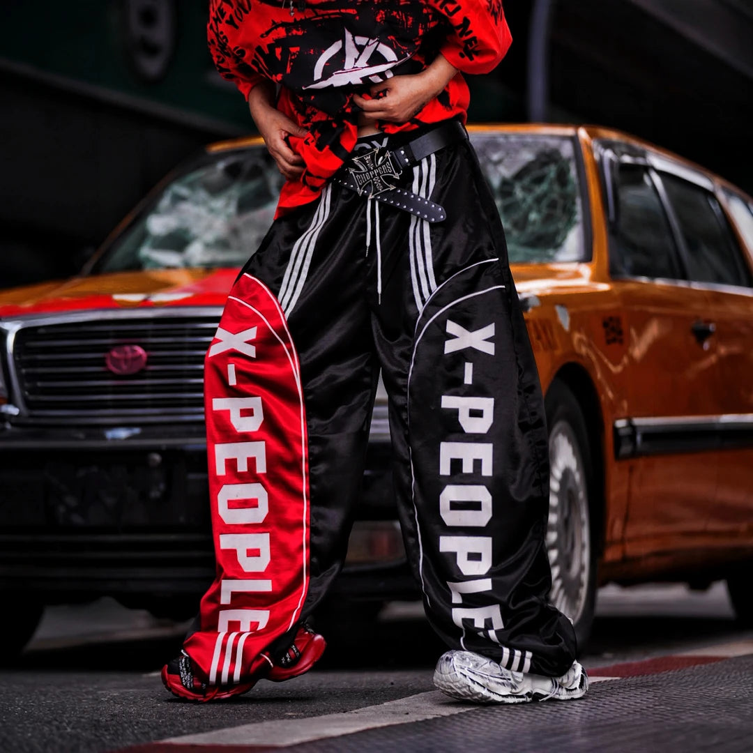 Sanhoostudio wide leg pants featuring lightweight glossy fabric construction and a scythe-cut silhouette with a relaxed fit. Designed for breathable summer styling with comfort, movement, and contemporary streetwear appeal.