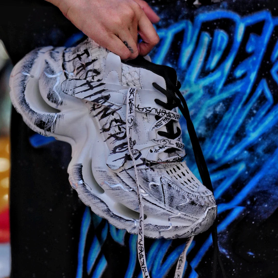 Sanhoostudio dad sneakers featuring grey and white graffiti-inspired detailing, cushioned sole construction, and a modern streetwear silhouette. Designed for everyday comfort, versatile styling, and standout urban fashion appeal with all-day wearability.