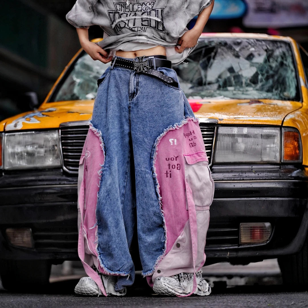 Sanhoostudio denim pants featuring distressed wash treatment, patchwork detailing, and a wide leg scythe-cut silhouette. Designed for modern streetwear styling with relaxed comfort and standout visual character for everyday wear.