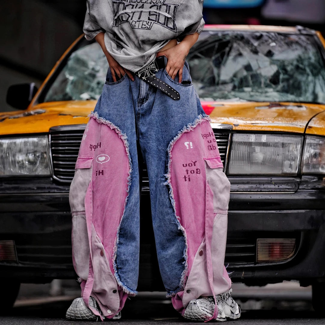 Sanhoostudio denim pants featuring distressed wash treatment, patchwork detailing, and a wide leg scythe-cut silhouette. Designed for modern streetwear styling with relaxed comfort and standout visual character for everyday wear.