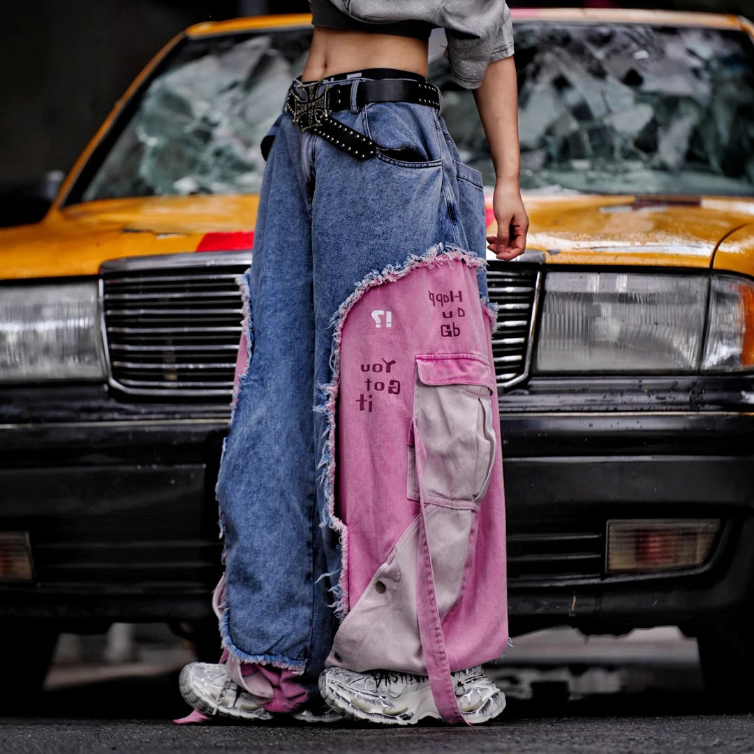 Sanhoostudio denim pants featuring distressed wash treatment, patchwork detailing, and a wide leg scythe-cut silhouette. Designed for modern streetwear styling with relaxed comfort and standout visual character for everyday wear.