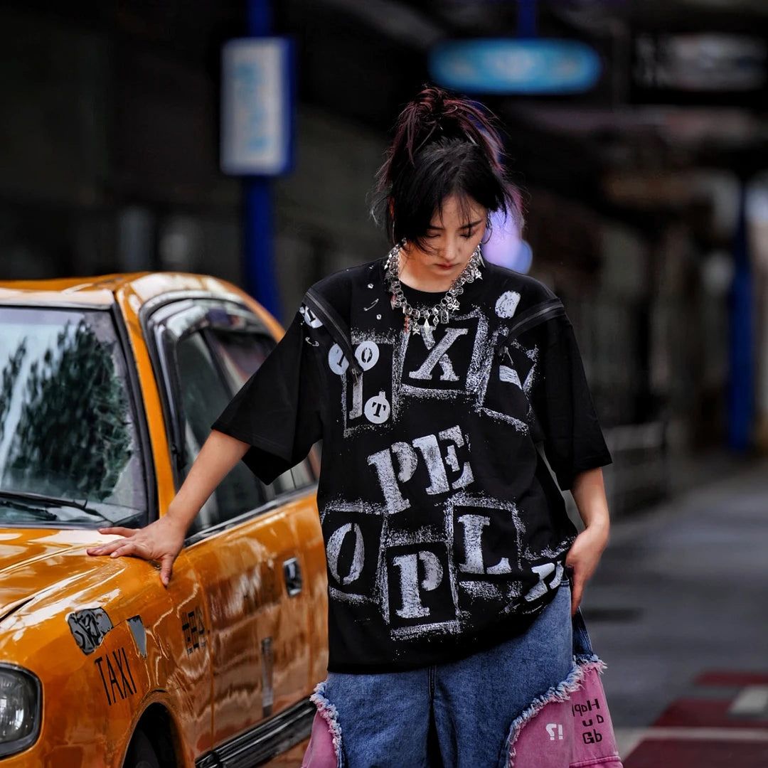Sanhoostudio short sleeve T-shirt featuring fracture-inspired spray-print artwork, breathable fabric construction, and a relaxed oversized fit. Built for summer streetwear outfits with lightweight comfort and standout graphic styling.