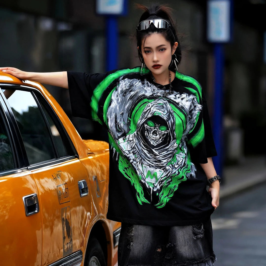 Sanhoostudio short sleeve T-shirt featuring Grim Reaper-inspired artwork, green flame graphics, premium spray-print detailing, and a relaxed oversized silhouette. Built for standout streetwear outfits with breathable comfort and striking visual impact.
