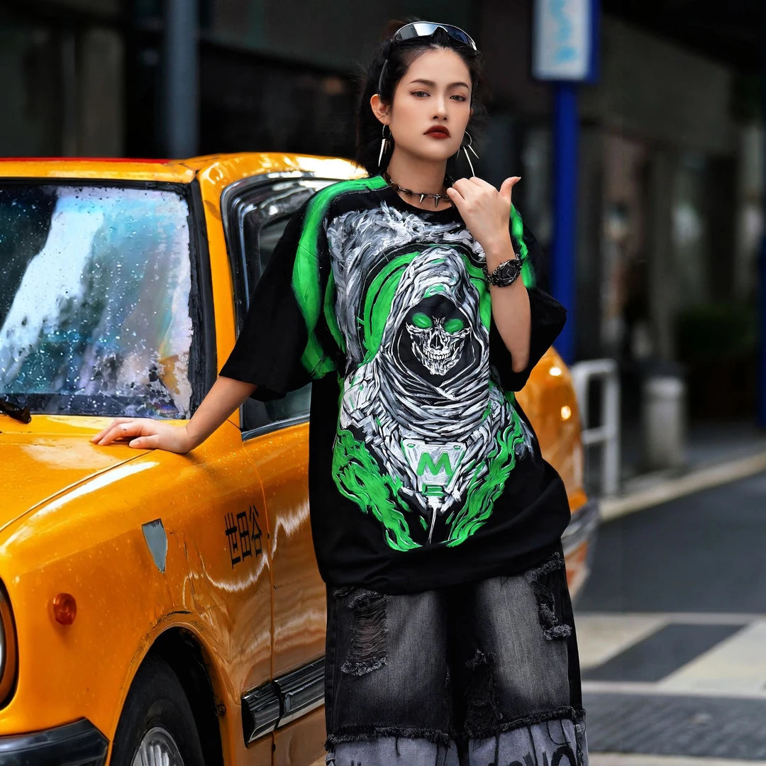 Sanhoostudio short sleeve T-shirt featuring Grim Reaper-inspired artwork, green flame graphics, premium spray-print detailing, and a relaxed oversized silhouette. Built for standout streetwear outfits with breathable comfort and striking visual impact.