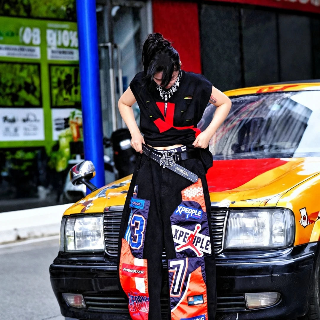 Sanhoostudio denim pants featuring patchwork applique detailing, distressed washed finish, and a wide leg scythe-cut silhouette. Designed for contemporary streetwear styling with relaxed comfort, durable construction, and standout everyday versatility.