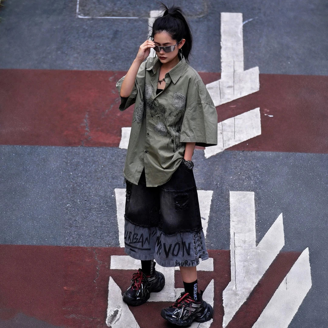 Sanhoostudio short sleeve shirt featuring vintage-inspired graffiti artwork, a relaxed oversized fit, and breathable fabric construction. Designed for effortless summer streetwear styling with comfort, versatility, and bold everyday appeal.