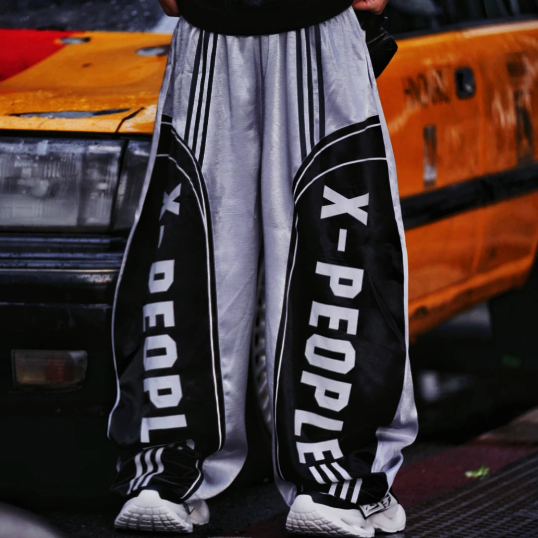 Sanhoostudio wide leg pants featuring a lightweight glossy fabric, relaxed scythe-cut silhouette, and breathable construction for summer comfort. Designed for versatile streetwear styling with a clean modern look and effortless everyday wear.