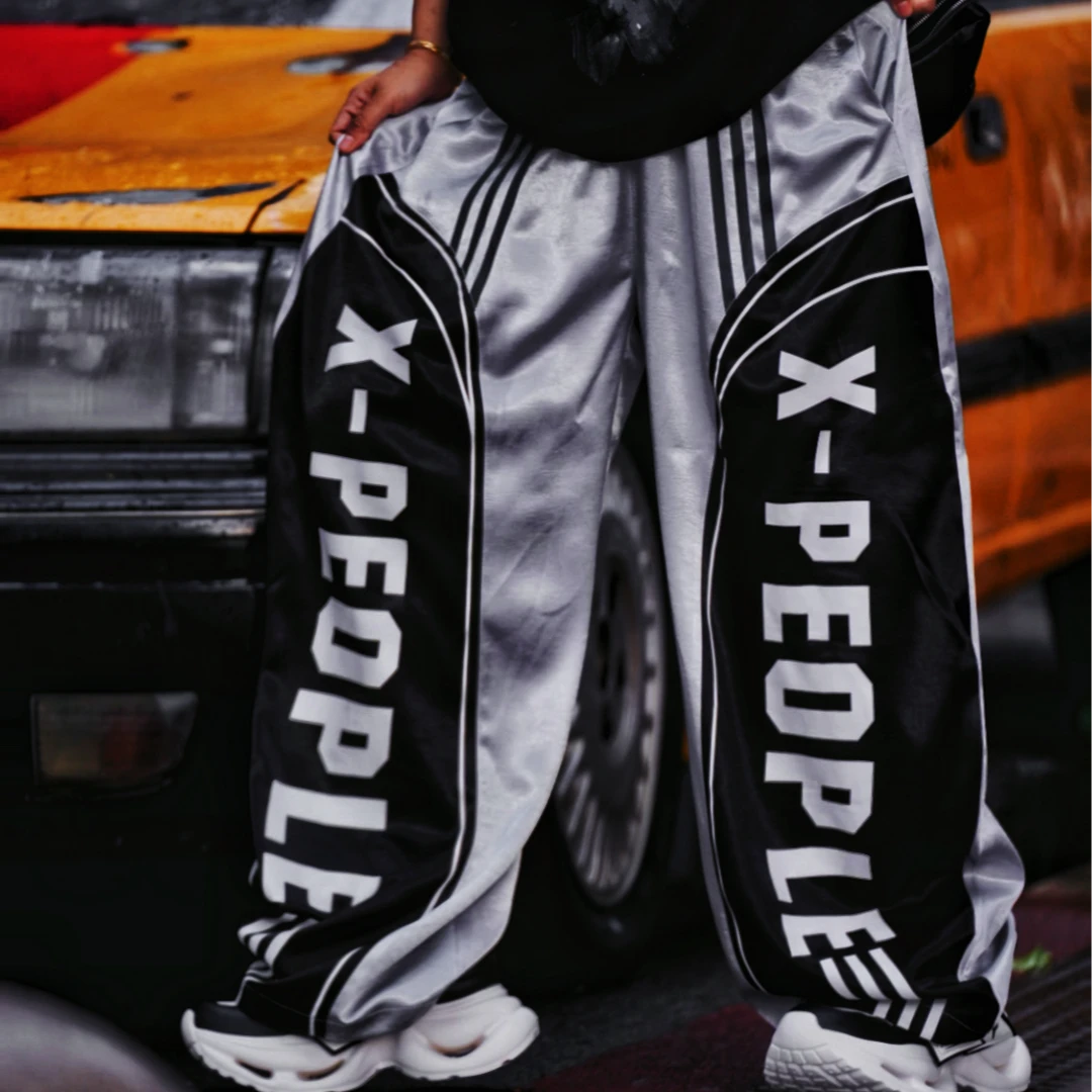 Sanhoostudio wide leg pants featuring a lightweight glossy fabric, relaxed scythe-cut silhouette, and breathable construction for summer comfort. Designed for versatile streetwear styling with a clean modern look and effortless everyday wear.