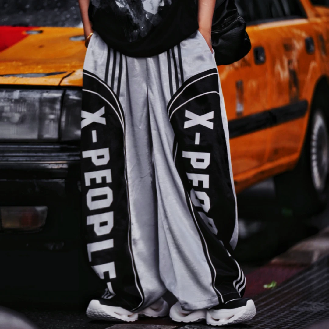 Sanhoostudio wide leg pants featuring a lightweight glossy fabric, relaxed scythe-cut silhouette, and breathable construction for summer comfort. Designed for versatile streetwear styling with a clean modern look and effortless everyday wear.