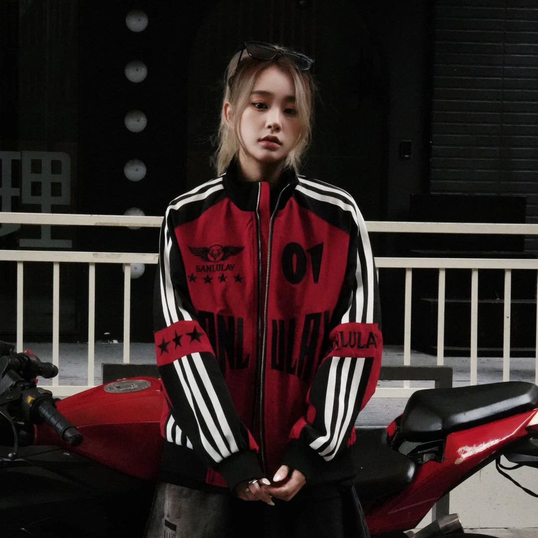 Sanhoostudio varsity jacket featuring red and black colorblock construction, number applique embroidery, striped detailing, and a relaxed oversized fit. Inspired by vintage racing and varsity aesthetics for bold fall streetwear styling and comfortable everyday wear.