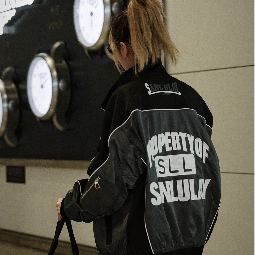 Sanhoostudio moto jacket featuring contrast colorblock panels, embroidered letter detailing, a structured stand collar, and a relaxed silhouette. Designed to combine vintage motorcycle influence with contemporary streetwear styling for bold and versatile everyday outfits.