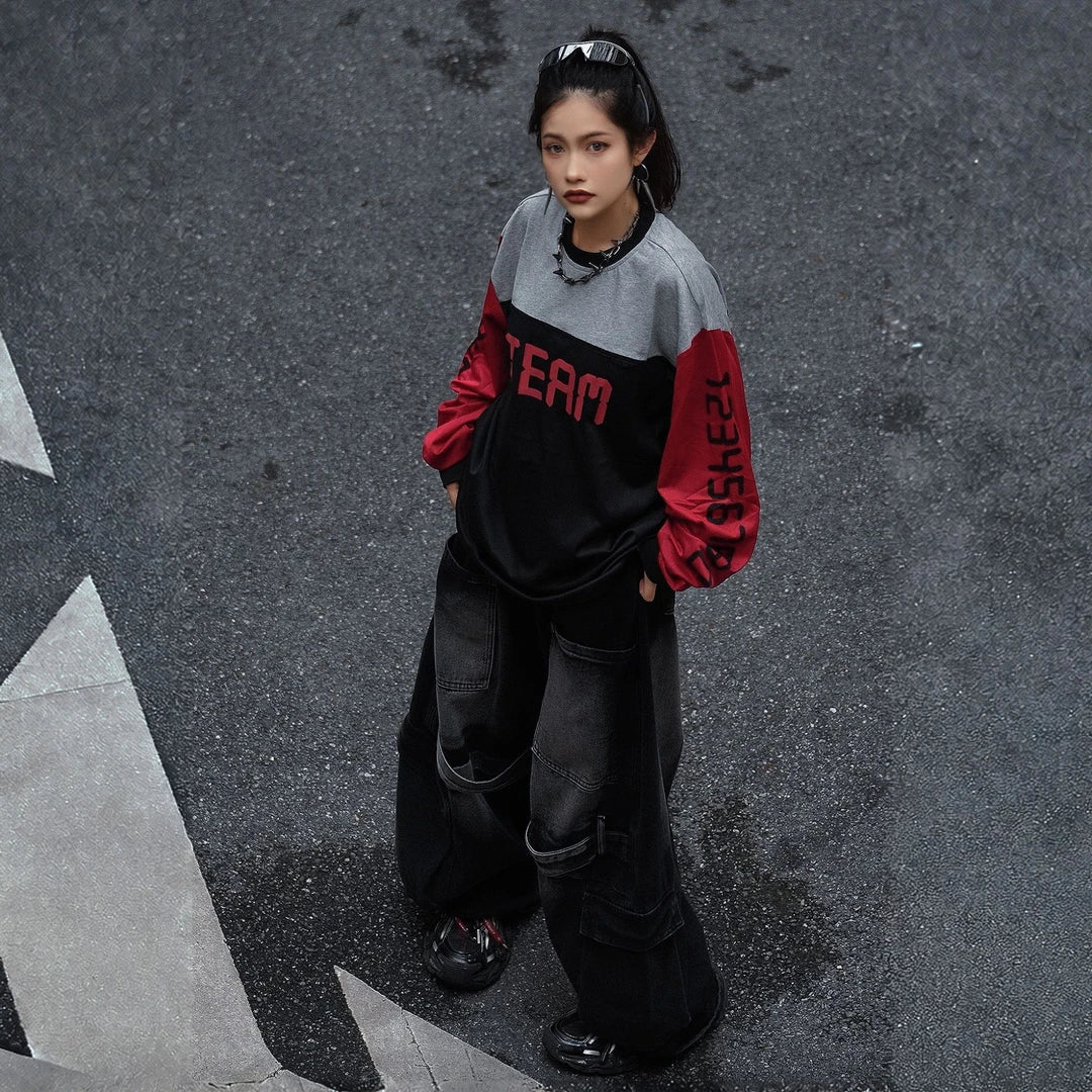 Sanhoostudio T-shirt featuring red, black, and grey colorblock patchwork with number and letter graphic prints. Designed with a relaxed streetwear silhouette for bold everyday styling, comfortable wear, and a distinctive high-street aesthetic.