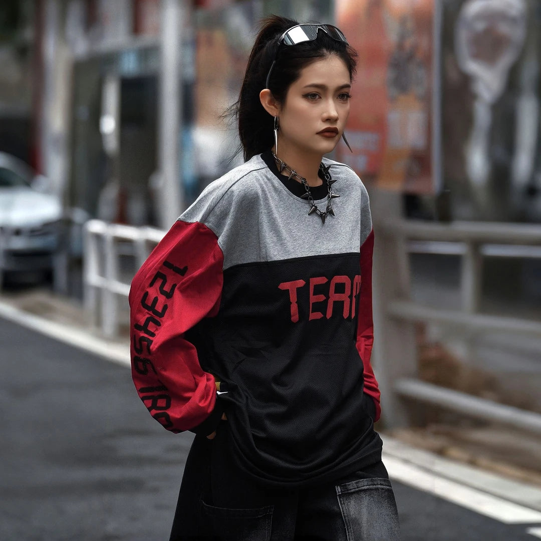 Sanhoostudio T-shirt featuring red, black, and grey colorblock patchwork with number and letter graphic prints. Designed with a relaxed streetwear silhouette for bold everyday styling, comfortable wear, and a distinctive high-street aesthetic.