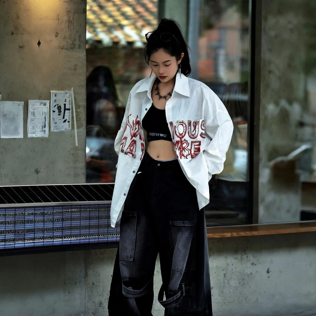 Sanhoostudio long sleeve shirt featuring metallic-effect letter detailing, relaxed dropped shoulders, and an oversized silhouette. Designed for dark high-street styling with bold visual texture, comfortable layering, and a sleek urban aesthetic for versatile everyday outfits.