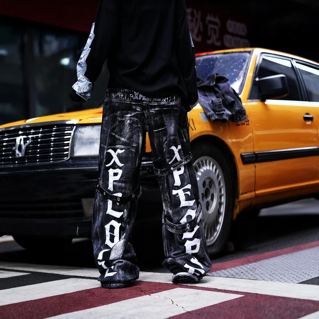 Sanhoostudio denim pants featuring heavyweight washed denim, distressed detailing, patchwork construction, and a relaxed wide leg scythe silhouette. Designed for bold streetwear styling with rugged vintage texture, comfortable movement, and versatile everyday urban wear.