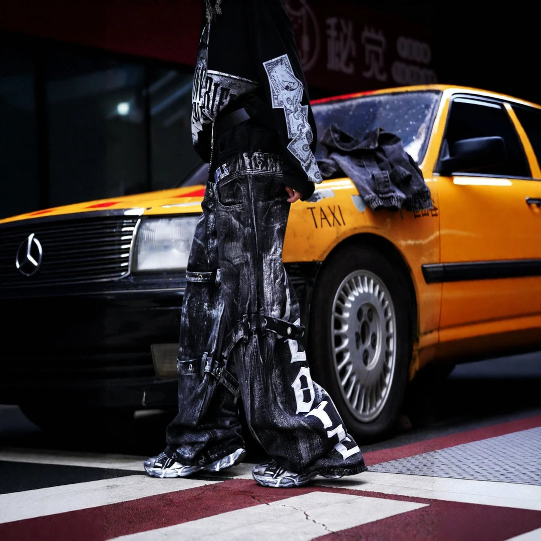 Sanhoostudio denim pants featuring heavyweight washed denim, distressed detailing, patchwork construction, and a relaxed wide leg scythe silhouette. Designed for bold streetwear styling with rugged vintage texture, comfortable movement, and versatile everyday urban wear.