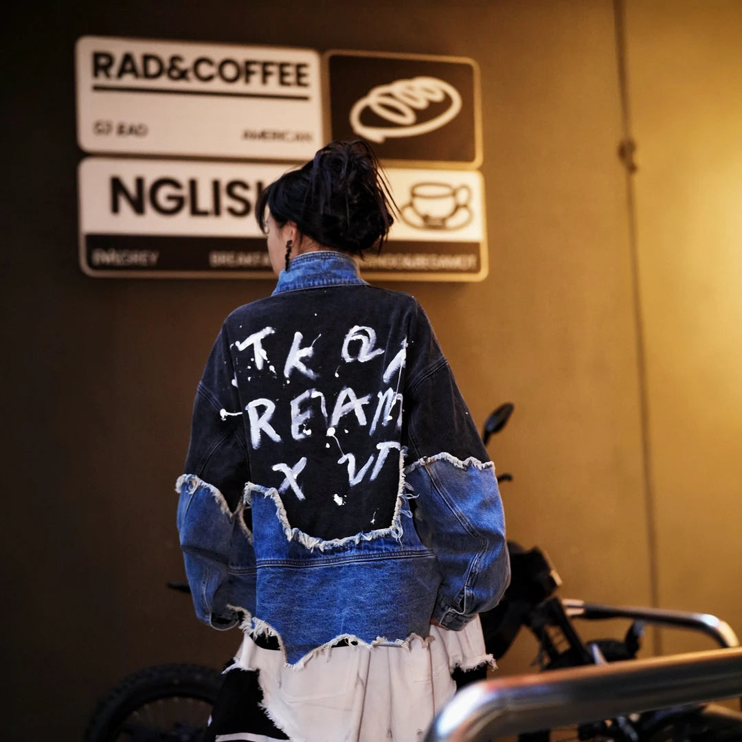 Sanhoostudio denim jacket featuring hand-painted graphics, distressed stain effects, brushed color detailing, mud-dye treatment, and a relaxed oversized silhouette. Designed for statement streetwear layering with rugged visual texture, vintage character, and distinctive everyday urban styling.