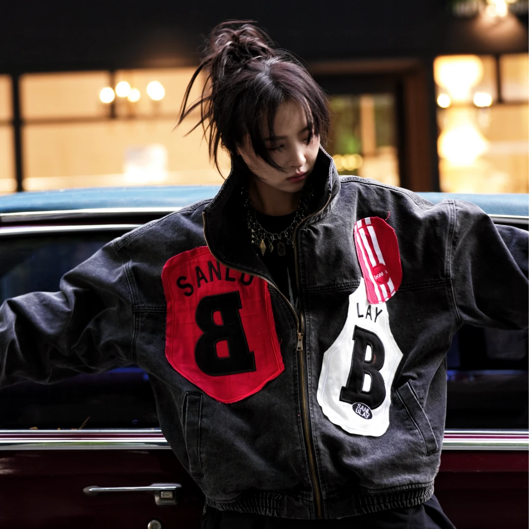 Sanhoostudio denim jacket featuring mixed patch applique embroidery, distressed stain effects, and a relaxed oversized silhouette. Designed for contemporary streetwear layering with handcrafted detailing, rugged denim texture, distinctive visual contrast, and bold everyday styling.