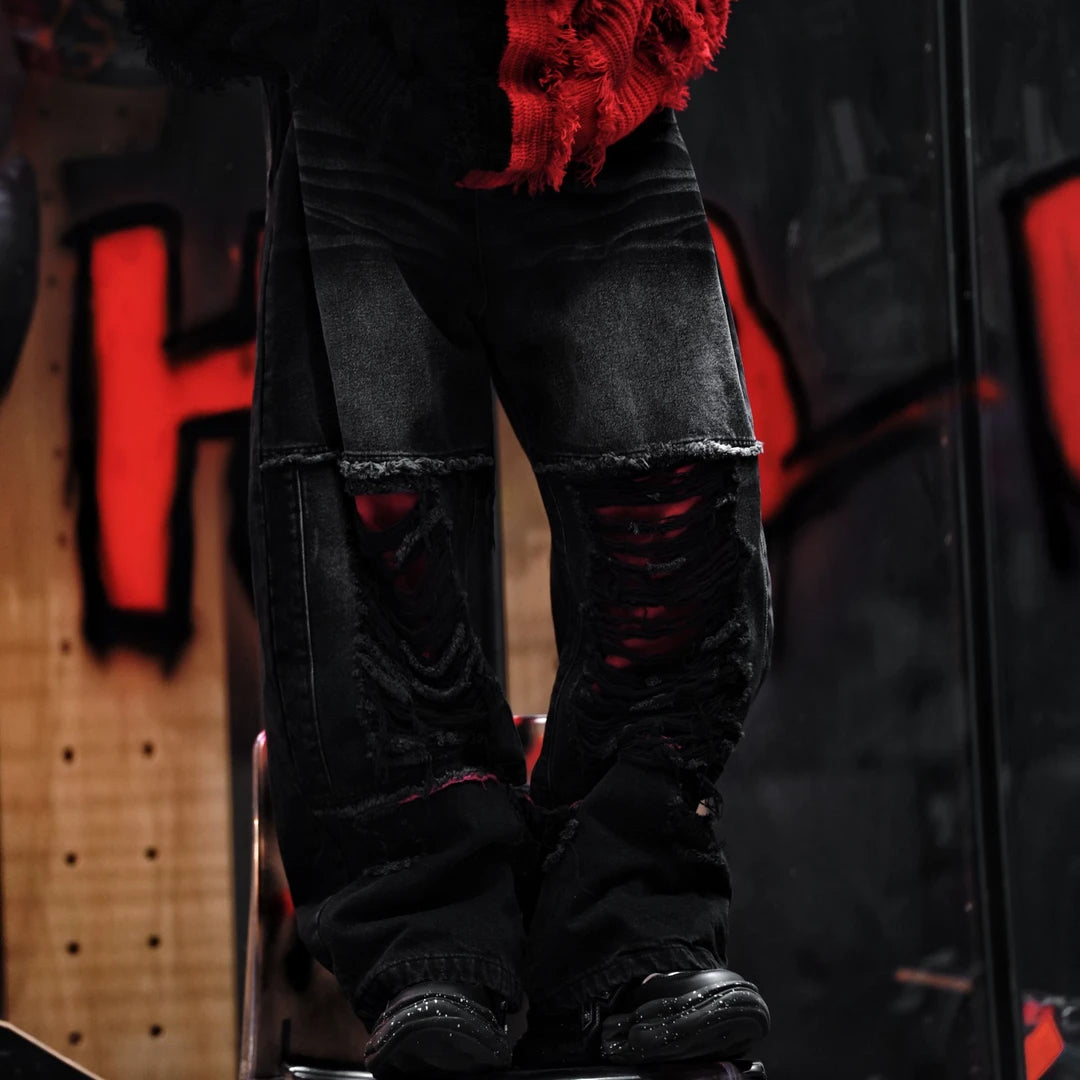 Sanhoostudio denim pants featuring a bold red colorway, heavyweight washed denim, distressed detailing, and patchwork construction with a wide leg scythe silhouette. Designed for statement streetwear styling with rugged texture, relaxed proportions, and distinctive visual appeal.