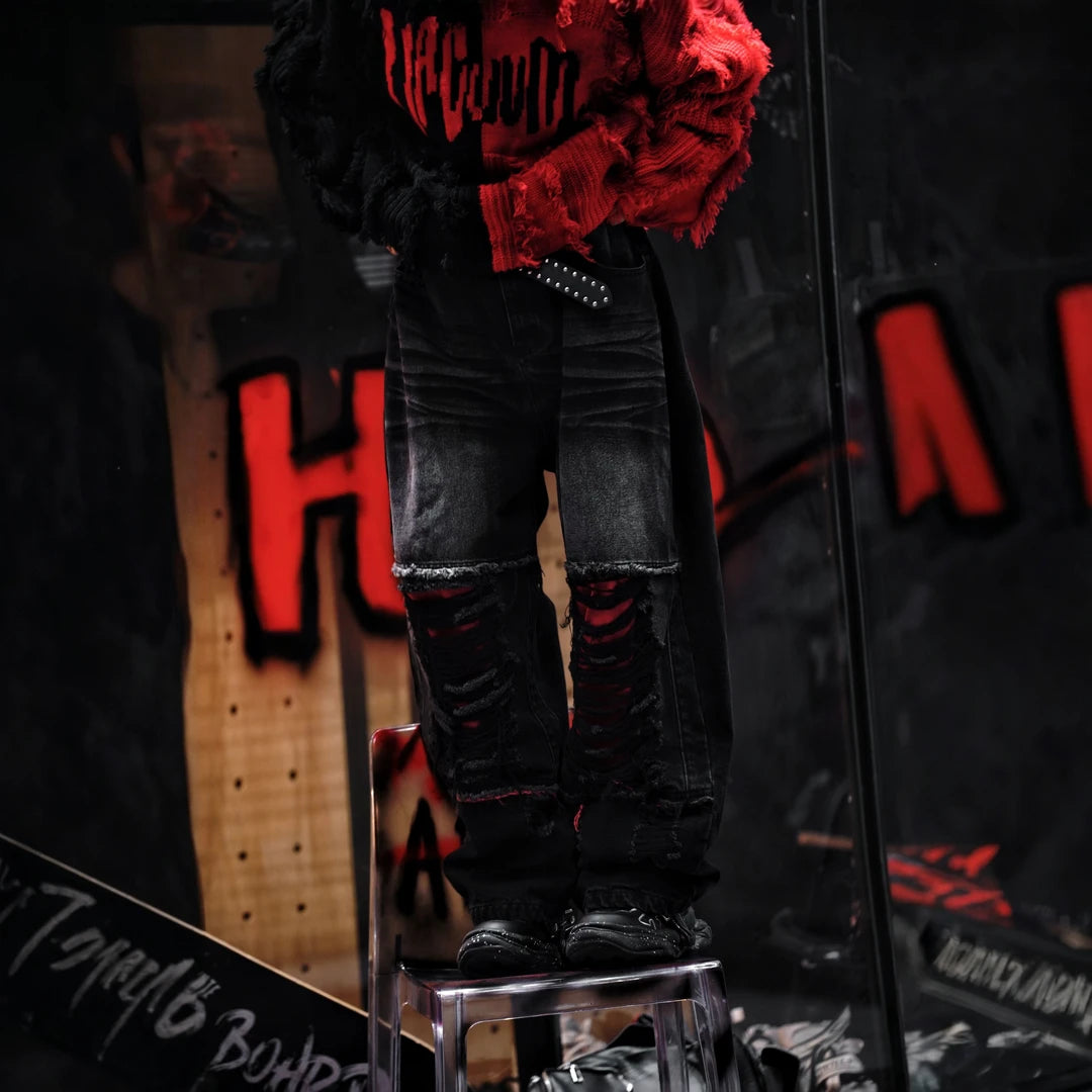 Sanhoostudio denim pants featuring a bold red colorway, heavyweight washed denim, distressed detailing, and patchwork construction with a wide leg scythe silhouette. Designed for statement streetwear styling with rugged texture, relaxed proportions, and distinctive visual appeal.