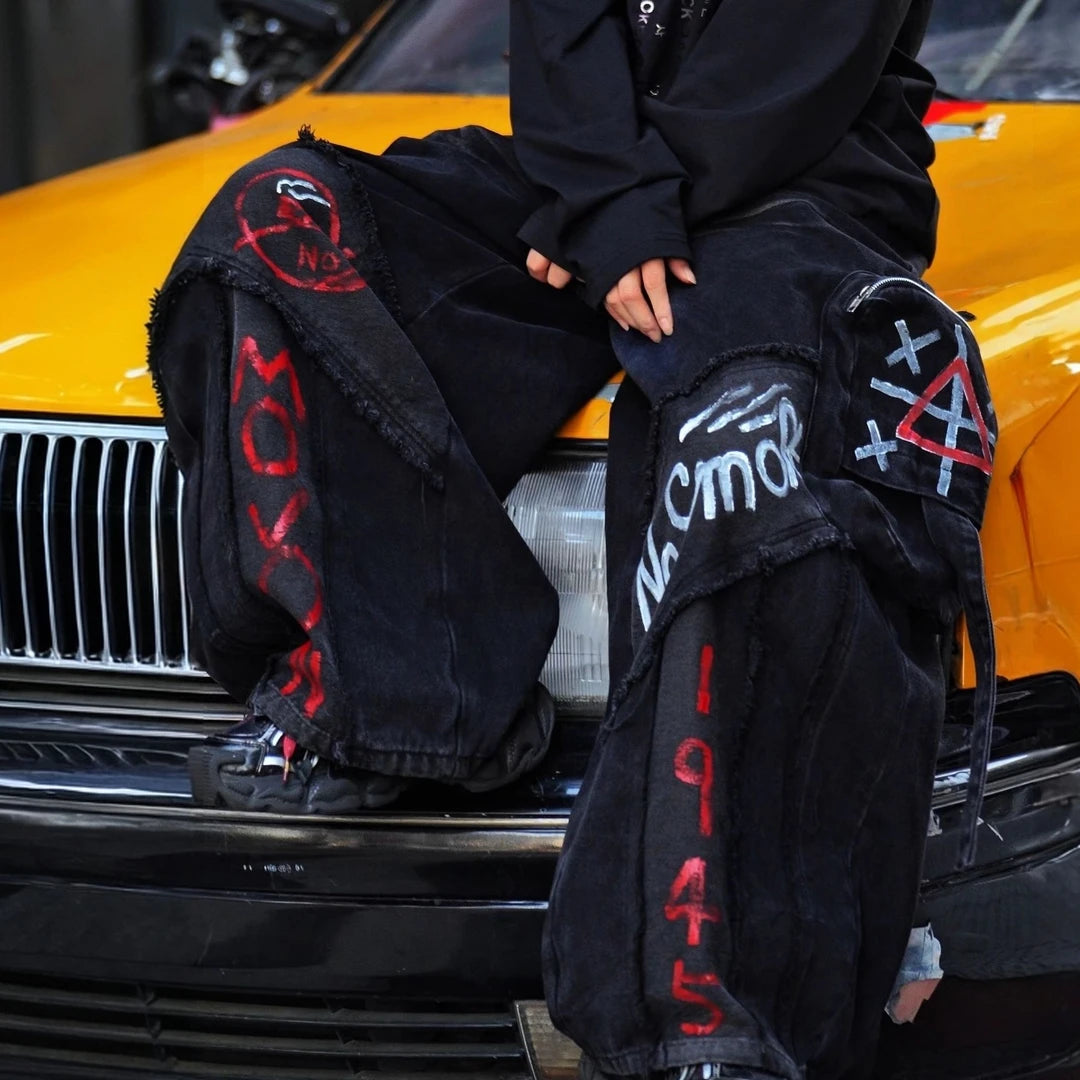 Sanhoostudio cargo denim pants featuring bold graffiti artwork, vintage washed treatment, distressed detailing, and a relaxed wide leg silhouette. Designed for American-inspired streetwear styling with rugged denim texture, functional workwear character, oversized proportions, and versatile everyday appeal.