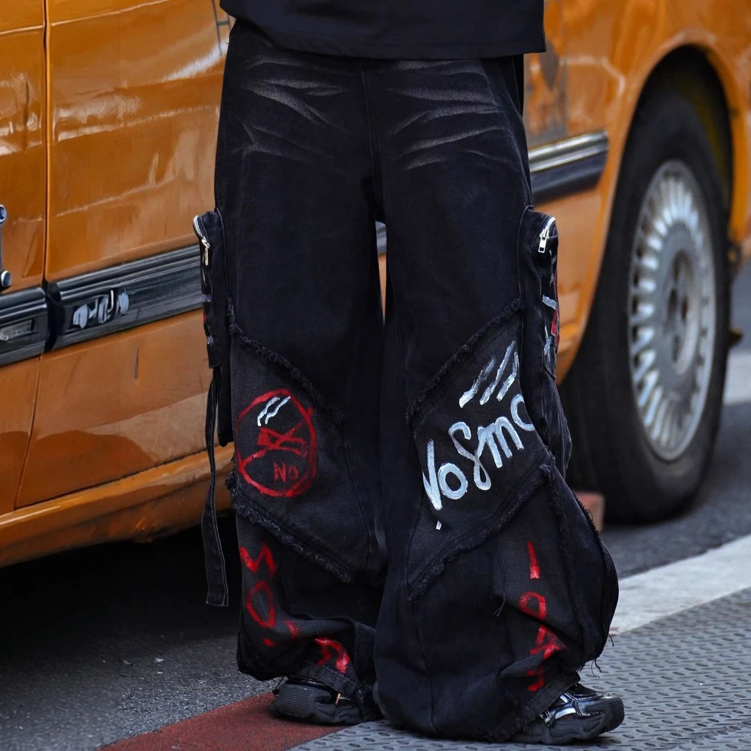 Sanhoostudio cargo denim pants featuring bold graffiti artwork, vintage washed treatment, distressed detailing, and a relaxed wide leg silhouette. Designed for American-inspired streetwear styling with rugged denim texture, functional workwear character, oversized proportions, and versatile everyday appeal.