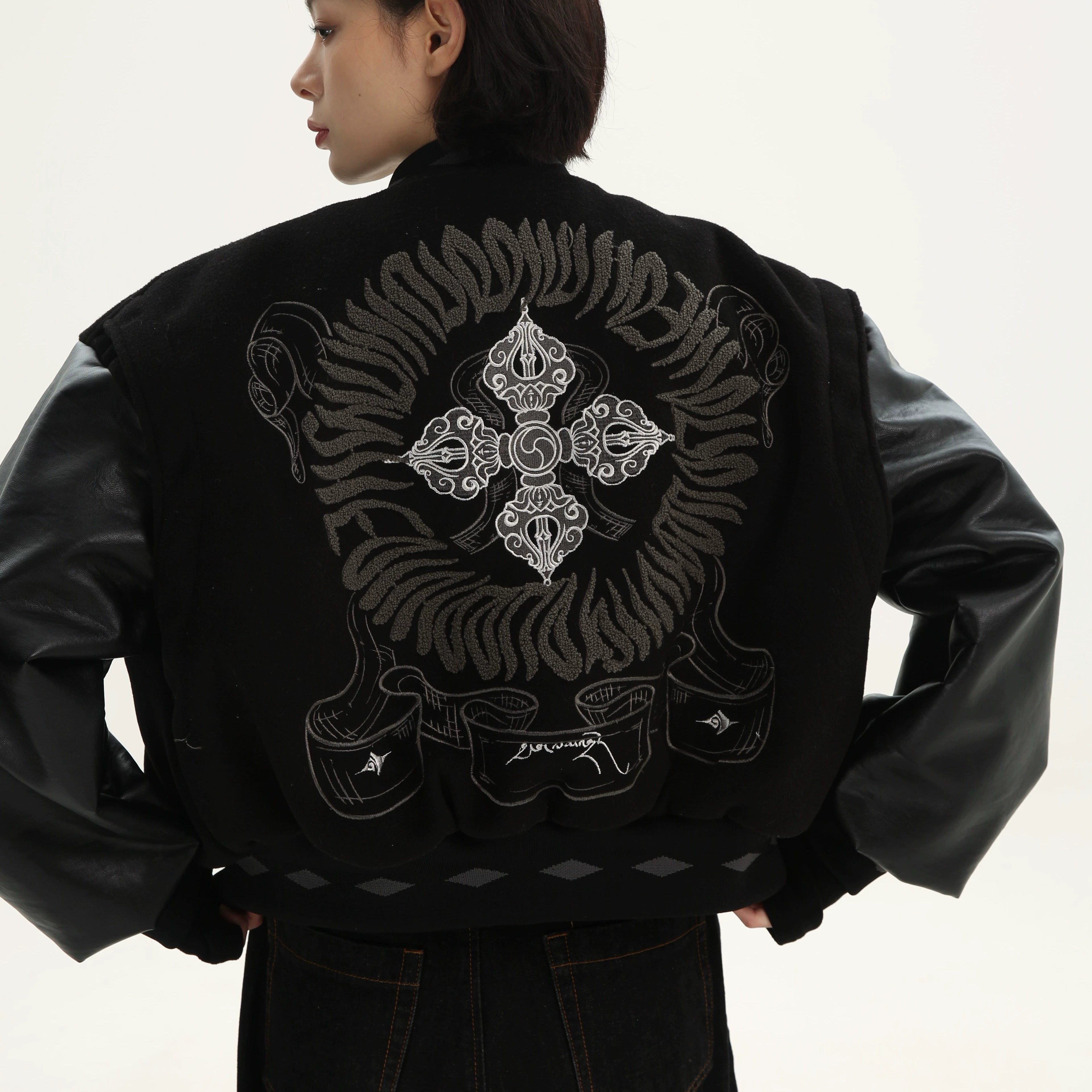 Sanhoostudio varsity jacket from the Dojie Unbound series, featuring Tibetan-inspired embroidery and heavyweight construction.
