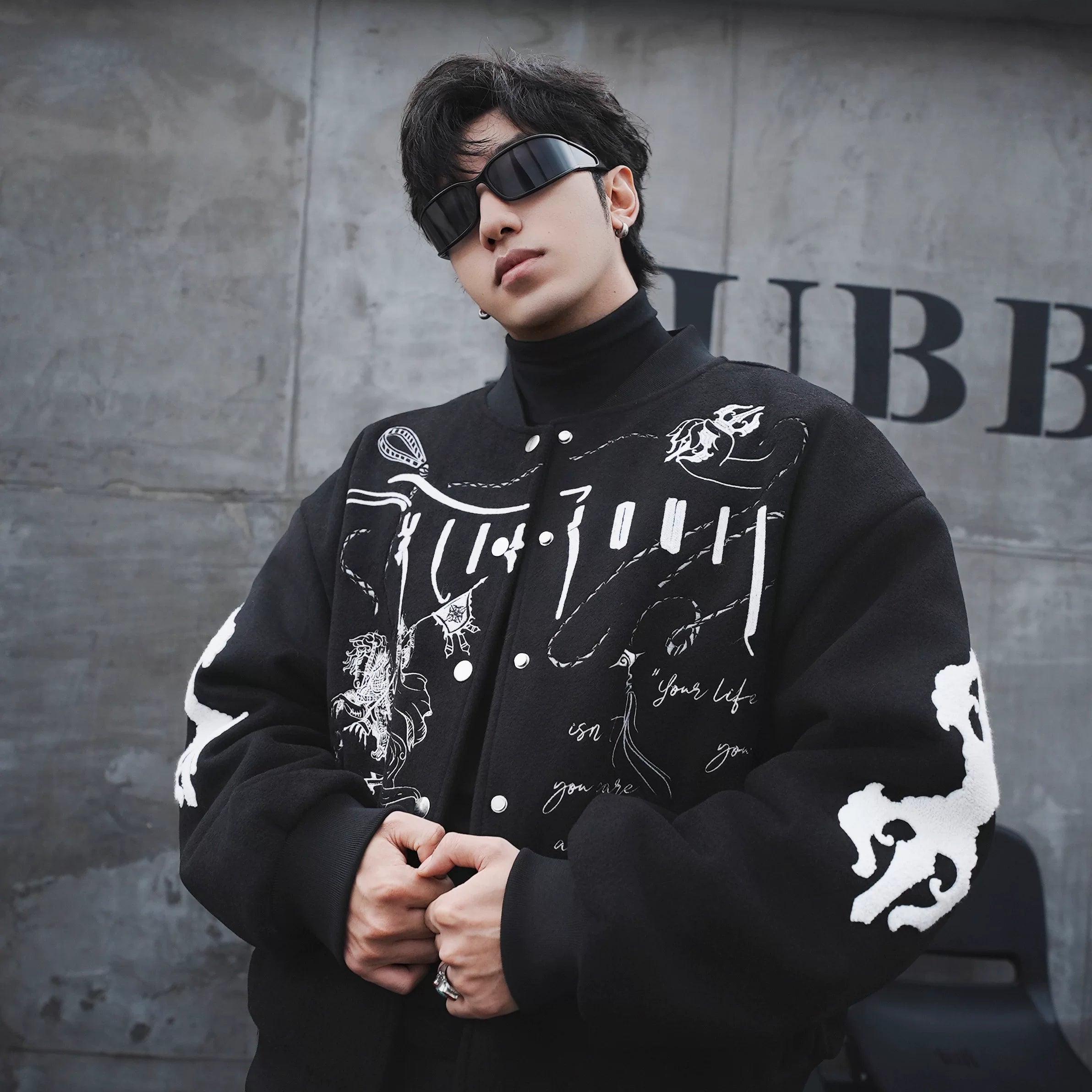 Sanhoostudio heavyweight varsity jacket featuring embroidery and wool blend fabric. Designed for bold unisex streetwear.