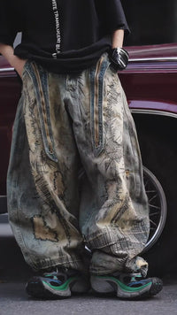 Sanhoostudio wide leg denim pants featuring distressed wash, heavy embroidery, and wasteland-inspired design. Built with a loose fit silhouette for bold streetwear styling.